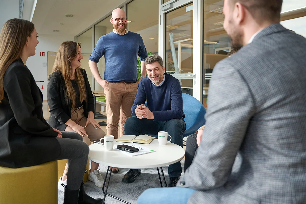 Gruppe sitzt für Nachhaltigkeitsberatung zusammen